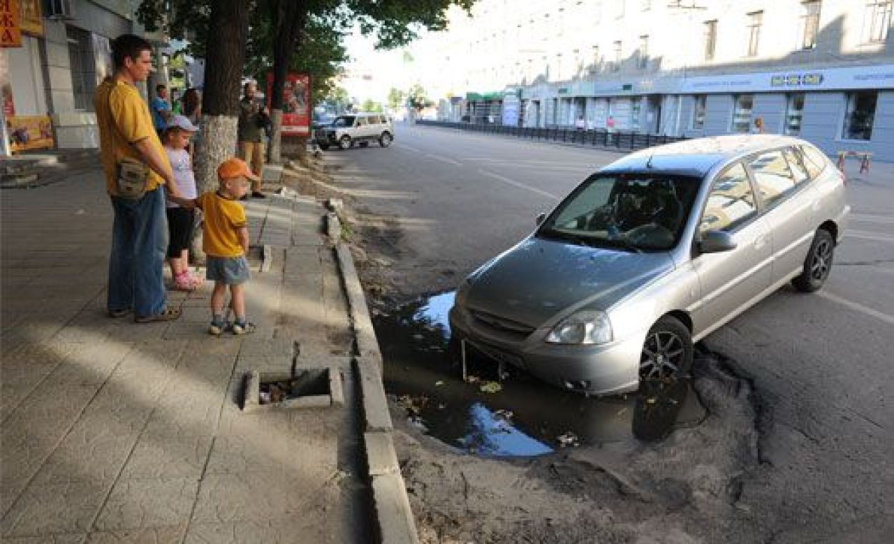 В центре Воронежа иномарка провалилась двумя колёсами в яму на дороге