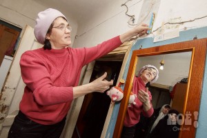 Любовь Васильевна Павлова измеряет линейкой размеры трещин